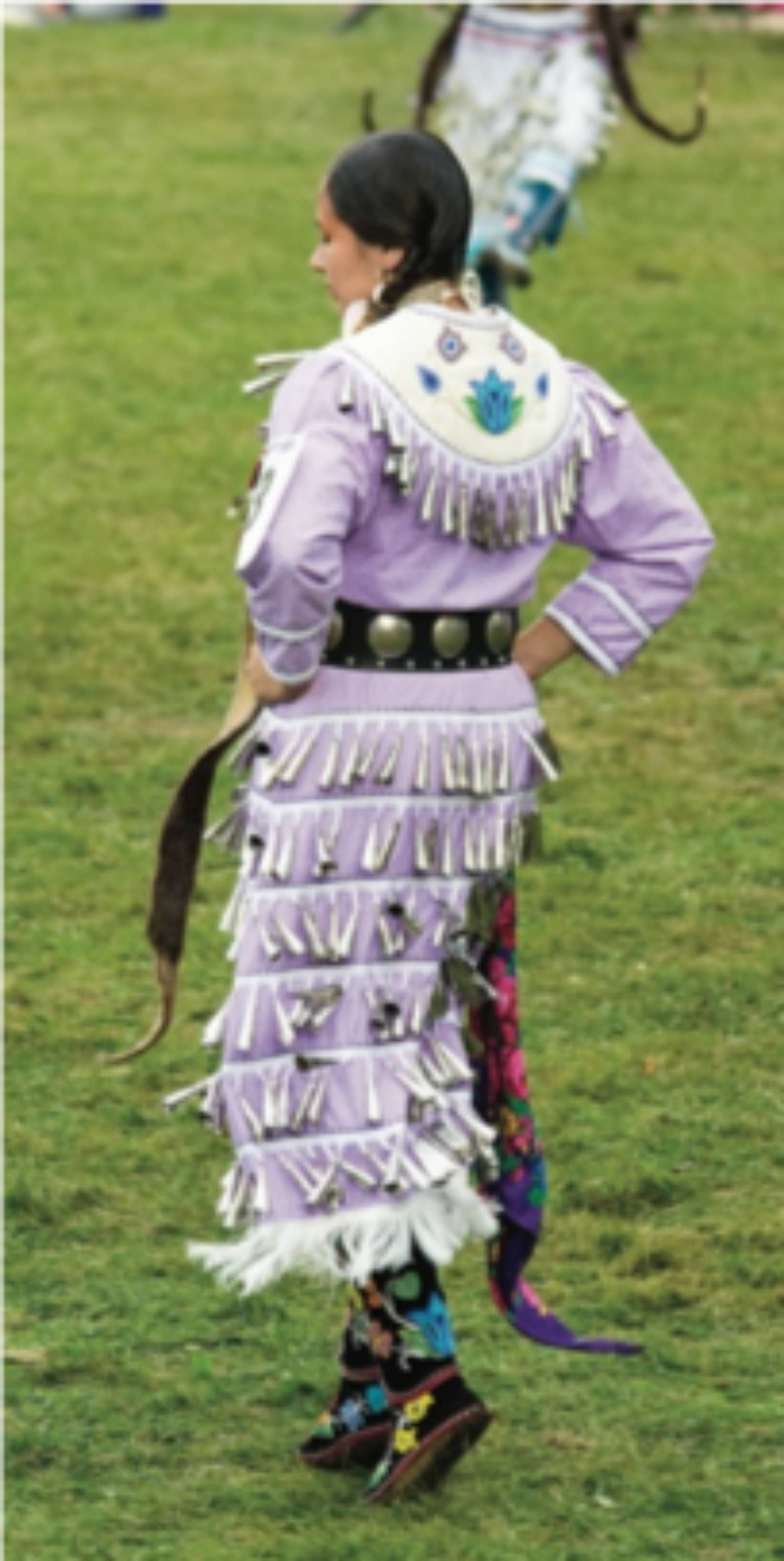 A woman wearing a jingle dress dancing at a Pow Wow